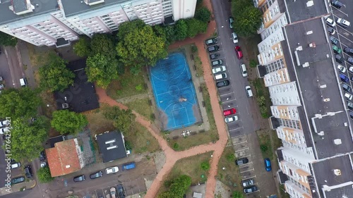 Aerial top down view of sports field between residential building in the city
