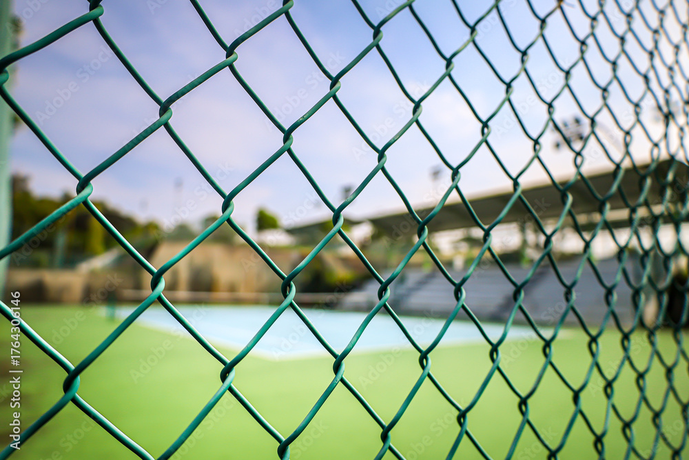Fototapeta premium Close Up Green Painted Chainlink Fence In Front of Tennis Court