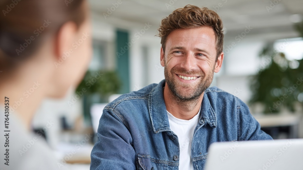 Fototapeta premium Man and woman in office setting smiling at each other.