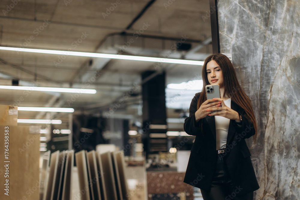 Fototapeta premium Young Woman Taking a Picture with Her Smartphone in a Modern Setting