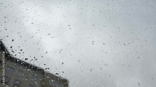 Rain window background. Water drops on glass, rainy day view with blurred buildings and grey sky, melancholy and depressed picture