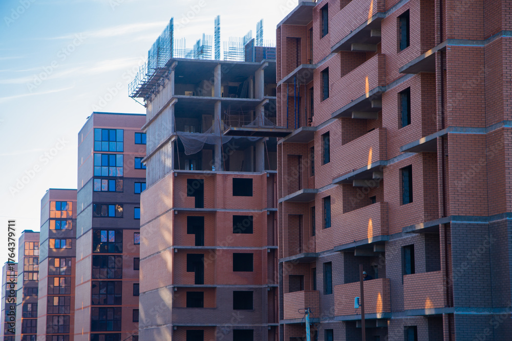 Fototapeta premium Modern residential buildings with brick facades and large windows are being built, showcasing urban planning and architectural innovation in a dynamic urban environment. High quality photo