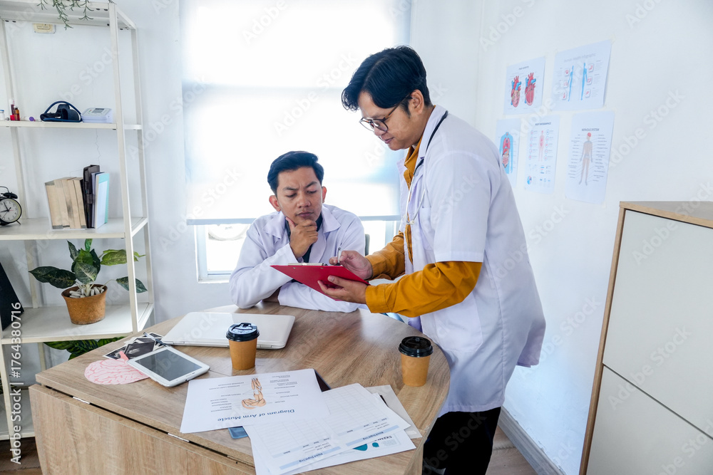 Obraz premium Asian Doctors Reviewing Patient Records in Office Clinic