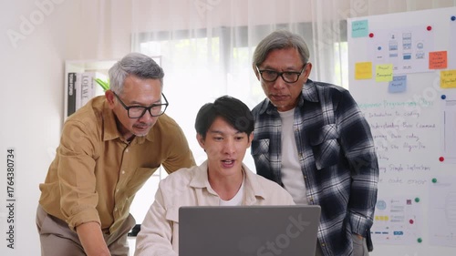 Team of developers collaborating in brainstorming and coding project at office workspace