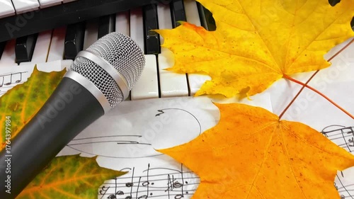 Creating the Sound of Autumn: A Music Producer's Setup with MIDI Keyboard, Microphone, and Headphones Surrounded by Warm Fall Leaves and Handwritten Sheet Music embodying seasonal creative inspiration