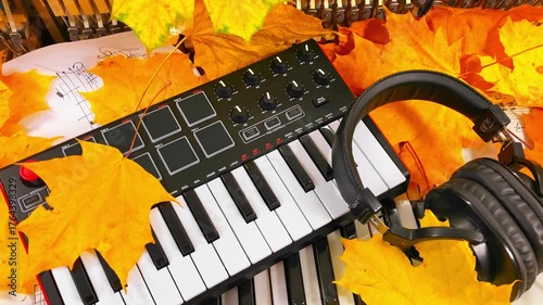 Creating the Sound of Autumn: A Music Producer's Setup with MIDI Keyboard, Microphone, and Headphones Surrounded by Warm Fall Leaves and Handwritten Sheet Music embodying seasonal creative inspiration