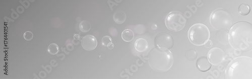 Transparent soap bubble or shampoo foam spheres floating on gray background for cosmetic or cleaning product design. Various glossy orbs and water droplets with ethereal effect and soft reflections.