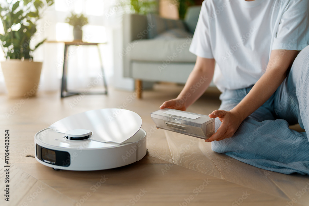 Fototapeta premium White robotic vacuum cleaner on wooden floor