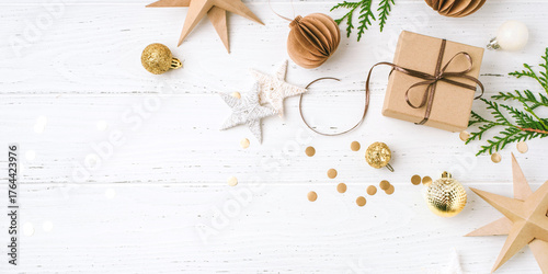 Festive Christmas background with gift box and Christmas decorations on white wooden table. Top view. Copy space for text.