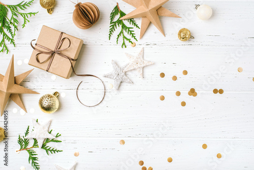 Festive Christmas background with gift box and Christmas decorations on white wooden table. Top view. Copy space for text.
