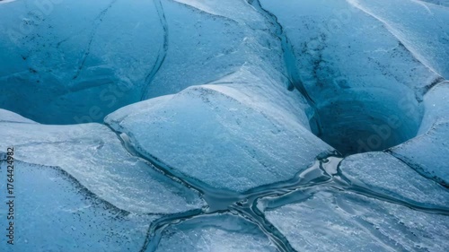 Cracked glacier melting under sunlight. Glacier erosion, global warming, natural water loss, polar climate shift, environmental damage, glacier impact on sea levels, climate crisis topic