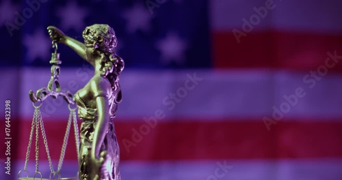 Old and dusty Lady Justice Bronze Statue with an inverted American flag on the background
