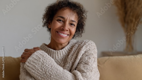 African descent woman in cozy knit embraces warmth, evoking Hygge vibes, celebrating World Kindness Day and Embrace Your Inner Autumn