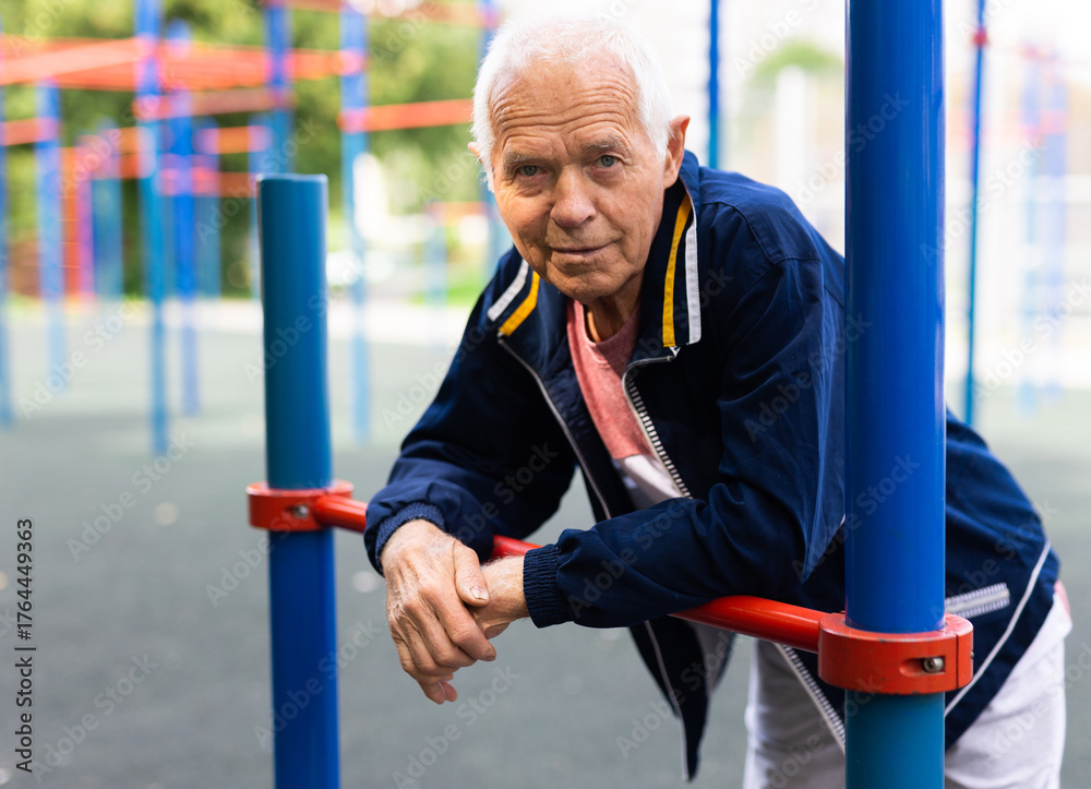 Obraz premium Portrait of sporty grandfather on playground in summer park