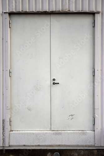 white closed steel door on plate wall background