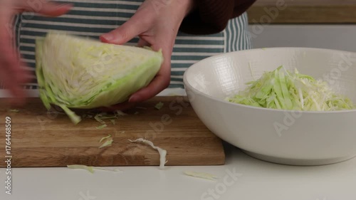 slicing cabbage with knife and put in bowl in domesic kitchen