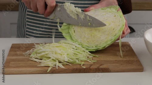 slicing cabbage with knife in domesic kitchen