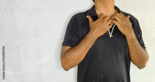 Closeup of young adult hand scratch and rub itching body skin near throat, neck and chest. Allergic reaction, food allergy, insect bite or mosquito bite irritation concept.