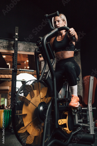 Caucasian fitness woman working out on an elliptical machine in a gym