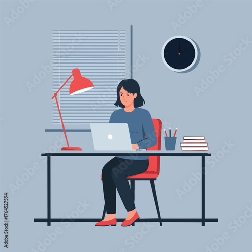 A focused young woman with short hair working on a laptop at her modern home office desk.