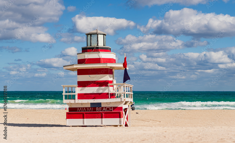 Fototapeta premium Lifeguard over Miami beach. Panoramic seascape of famous coastline. Summer in Miami Beach. Miami Beach jetty. Rescue tower against the blue sky in Miami. Beautiful coastal view of Florida.