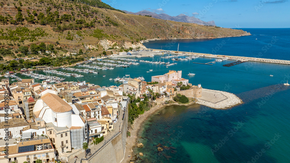 Fototapeta premium Aerial view of the historic centre of Castellammare del Golfo, a town located in the province of Trapani, Sicily, Italy. In the background is the tourist port overlooking the Mediterranean Sea.