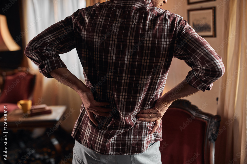 Obraz premium Man with hip, back and sciatica pain at home.