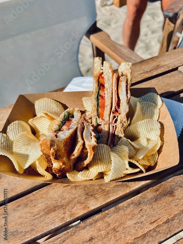 Club sandwich with chips on wooden table
