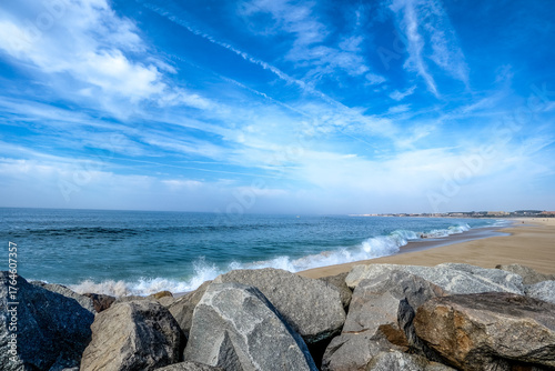 Seascape with rocks, waves and cloudy blue sky in Portugal