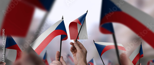 Czechia flags in their hands on a blurred urban background