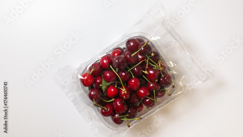Vibrant cherries nestled in recyclable plastic evoke summer solstice feasts and ancient Slavic Kupala Night rituals, sweetly beckoning