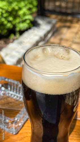 Fotografija Foamy stout glass whispers velvety tales of Oktoberfest camaraderie and Internat