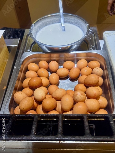 Fresh brown eggs and bowl of batter in stainless steel trays