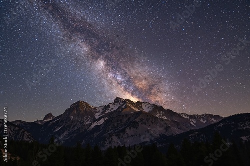 Galaxy arching above rugged peaks