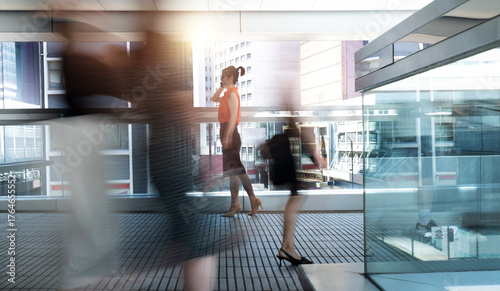 Woman using phone and walking on footbridge