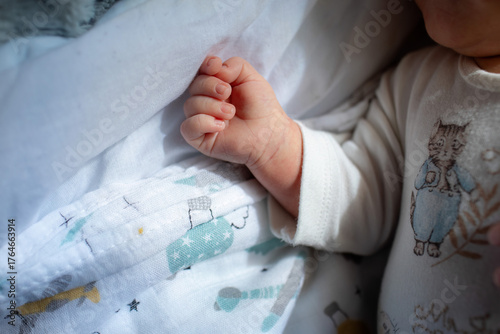 Close-up of newborn baby hand resting on blanket