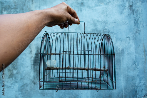 Hands holding an empty cage