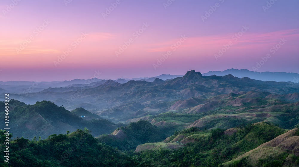 Fototapeta premium Rolling verdant hills stretch across the landscape beneath a vibrant pink and purple twilight sky