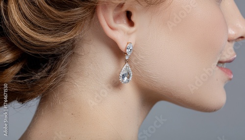 Elegant teardrop diamond earrings sparkle on a woman's ear, radiating luxury and sophistication for special occasions.