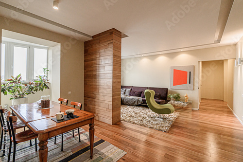 Φωτογραφία Cozy living space with a dining area, separated by a wooden accent wall