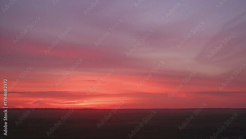 Fototapeta premium The horizon glows with shades of pink and orange as the sun sets, marking the close of a stunning day.