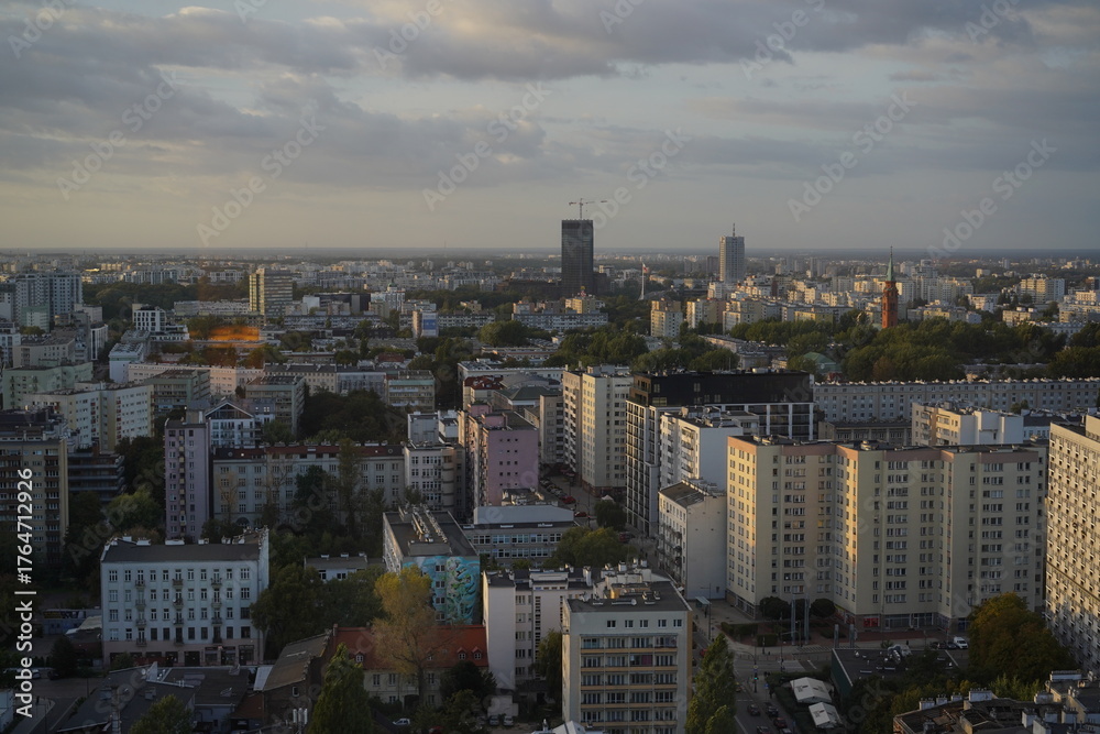 Fototapeta premium Overview of a modern city skyline during sunset with clouds in the sky