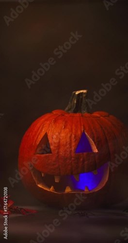 Creepy Halloween Pumpkin with Glowing Red Eyes and Smoke on black background