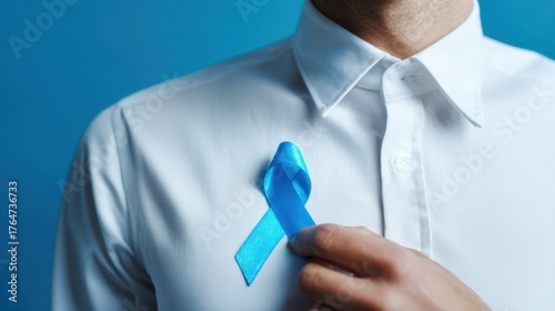 Man in white shirt pins blue ribbon to show awareness and support for a cause