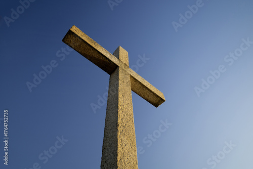 A stone Christian cross, with a blue sky in the background...2