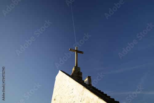 A stone Christian cross, with a blue sky in the background...1