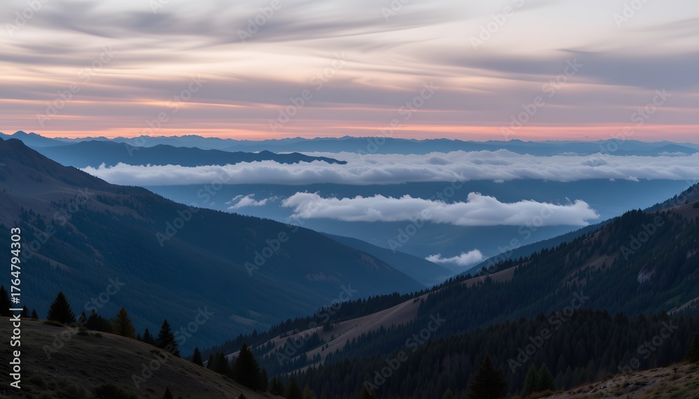 Obraz premium Majestic Mountain Landscape with Rolling Clouds and Vibrant Sunset Glow Over the Horizon