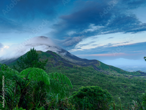Grüne Landschaft mit Berg und Wolken vor Sonnenaufgang