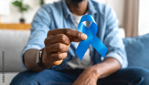 Man Sitting and Holding Blue Ribbon – Symbol of Prostate Cancer Awareness and Support