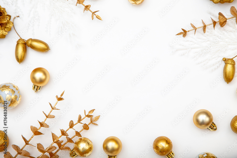 Fototapeta premium Elegant winter background with golden baubles, acorns and pine cones. White minimalist Christmas copy space.